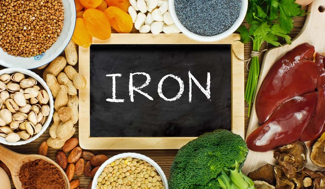 iron rich foods such as liver, buckwheat, eggs, parsley leaves, dried apricots, cocoa, lentil, bean, blue poppy seed, broccoli, dried mushrooms, peanuts and pistachios on wooden table