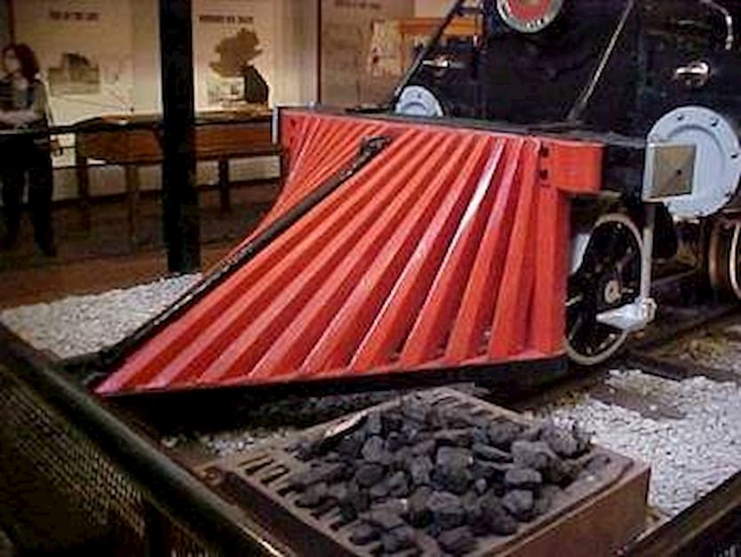 The cowcatcher, also known as the pilot, is a device mounted on the front of a locomotive to deflect obstacles on the track that might derail the train