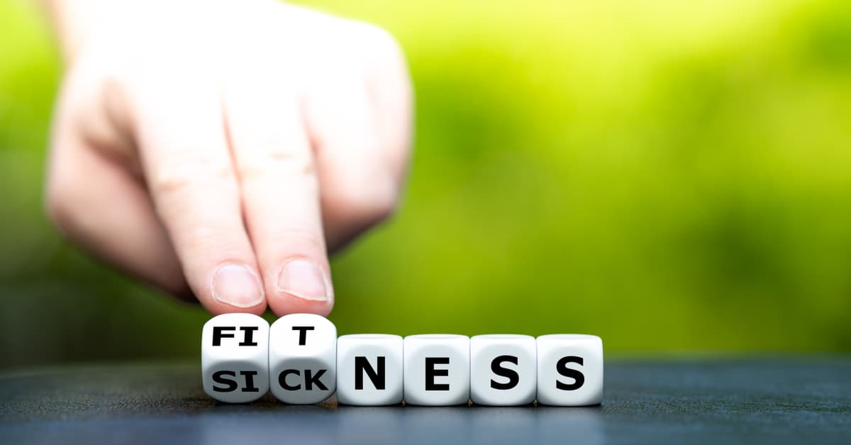 Hand turns dice and changes the word "sickness" to "fitness".